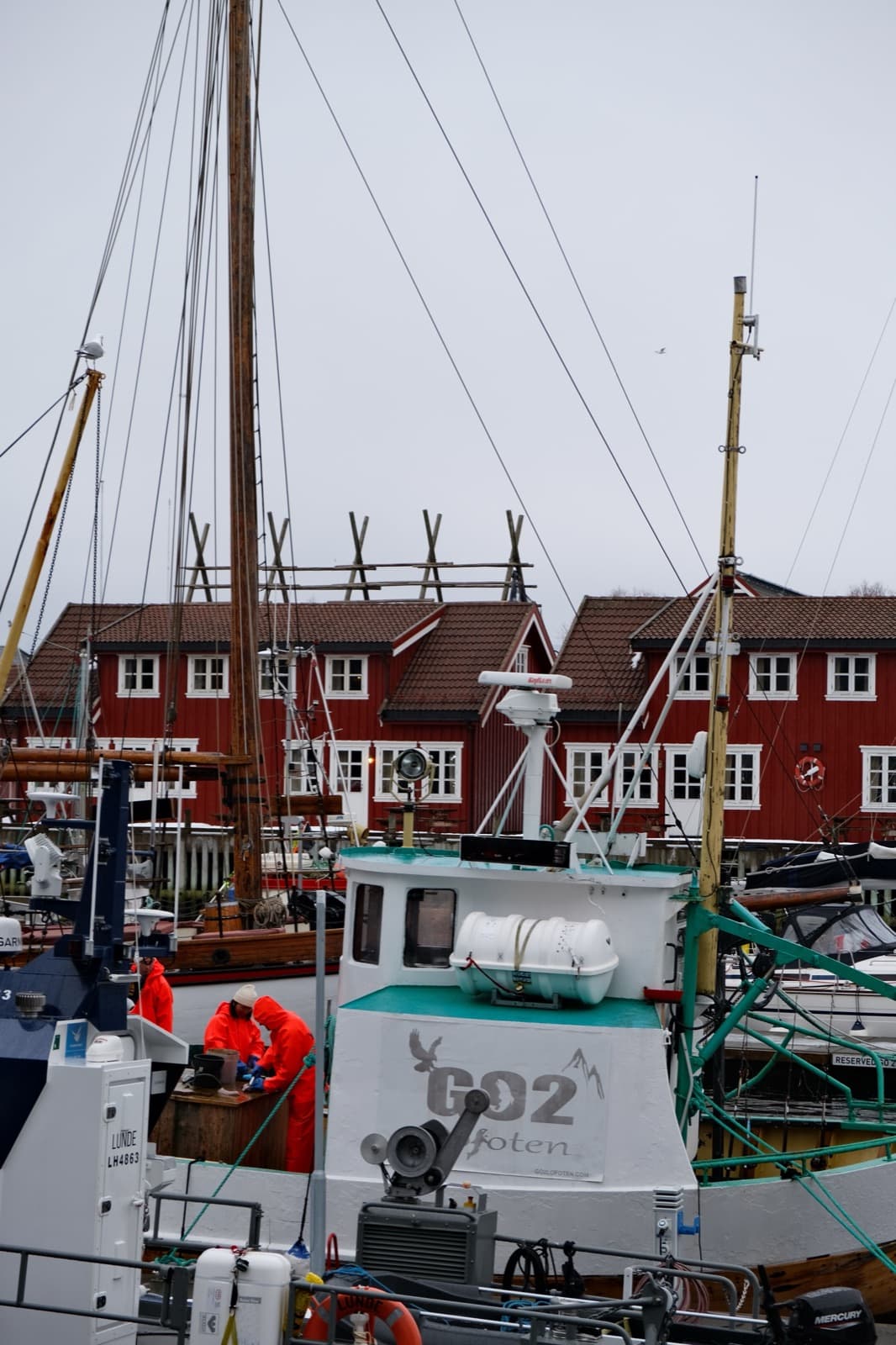 Fiskebåt ved kaia, hjeller og rorbuer bak.